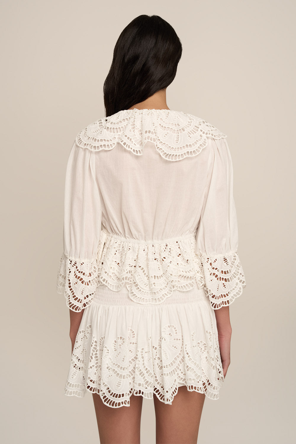 Poupette St Barth Blouse Casta in natural white, plain fabric, shown from the back, styled with a miniskirt.