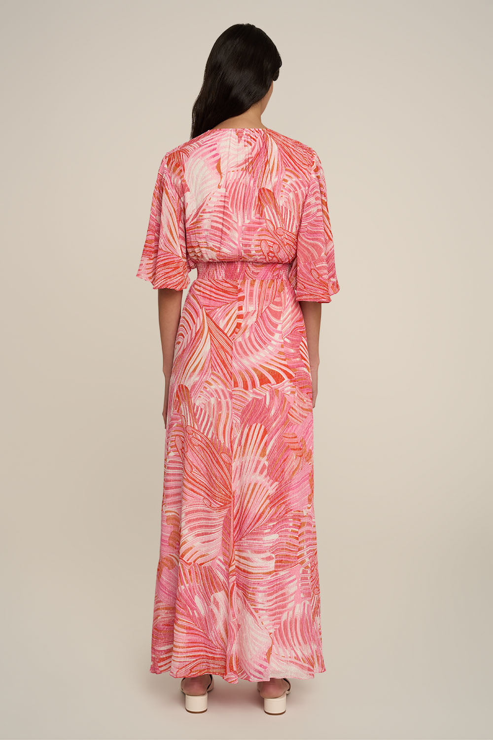 Pink long dress named Grace by Poupette St Barth, featuring flowing fabric and elegant design, shown from the back.