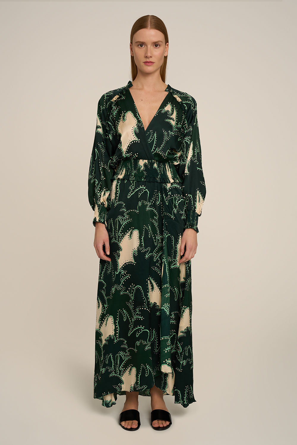 Green Kelly Long Dress by Poupette St Barth featuring flowing fabric and a stylish silhouette, shown from the front.