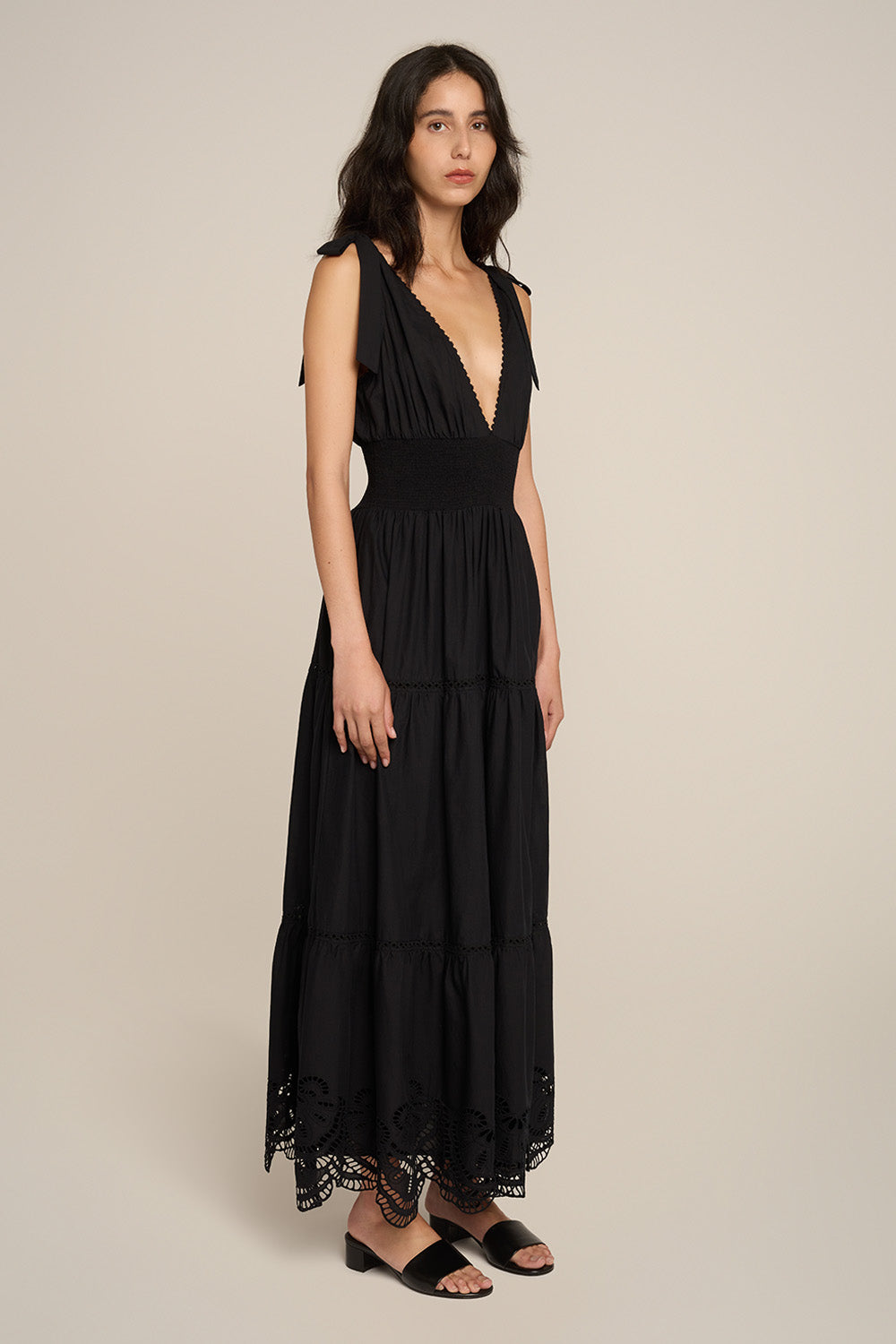 Black Long Dress Luiza by Poupette St Barth, featuring a flowing silhouette and elegant design, shown from a side view.