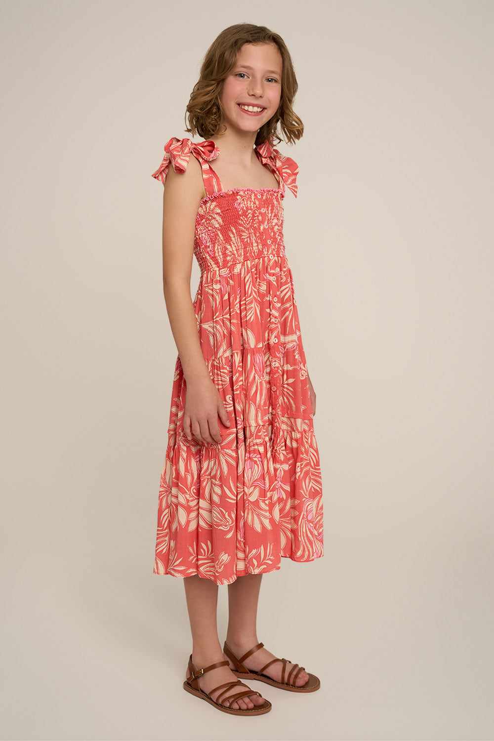 Pink long dress for girls by Poupette St Barth, featuring a flowy design and elegant style, shown from the side.