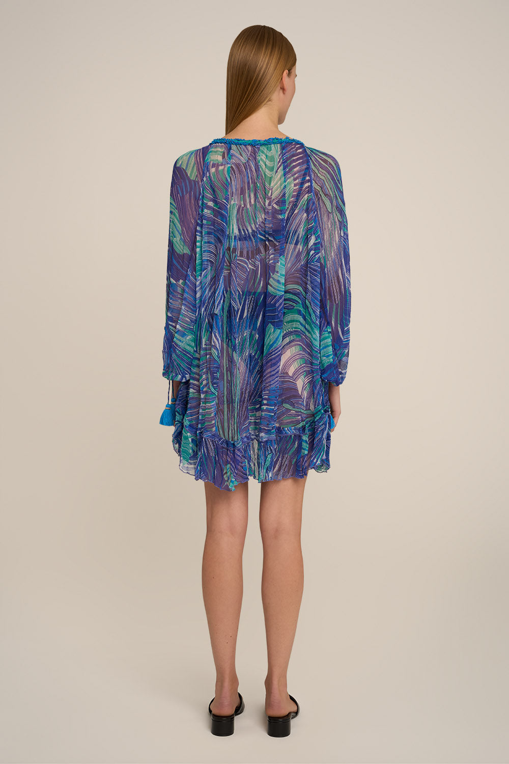 Blue Nava Poncho by Poupette St Barth featuring a relaxed fit and intricate pattern, shown from the back.