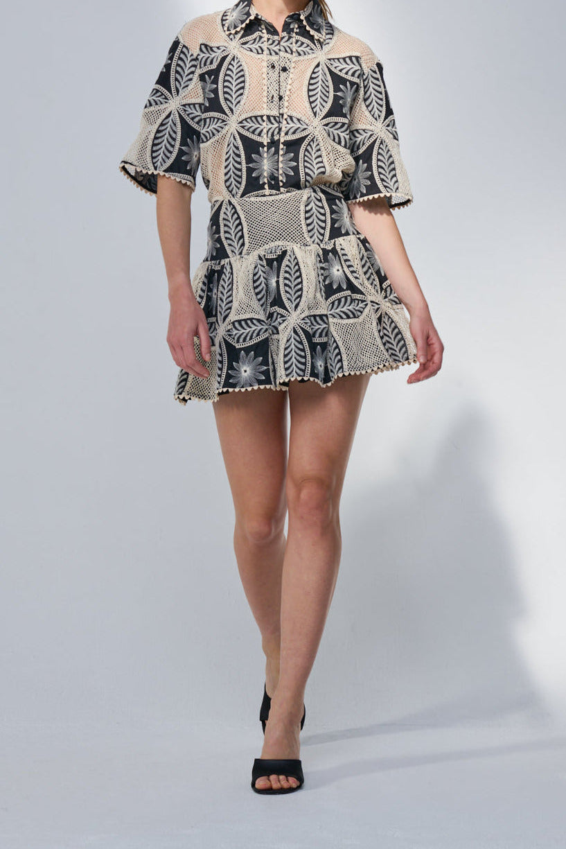 Black Mini Skirt Colleen by Poupette St Barth, featuring a fitted silhouette and subtle mandala pattern, shown on a model.