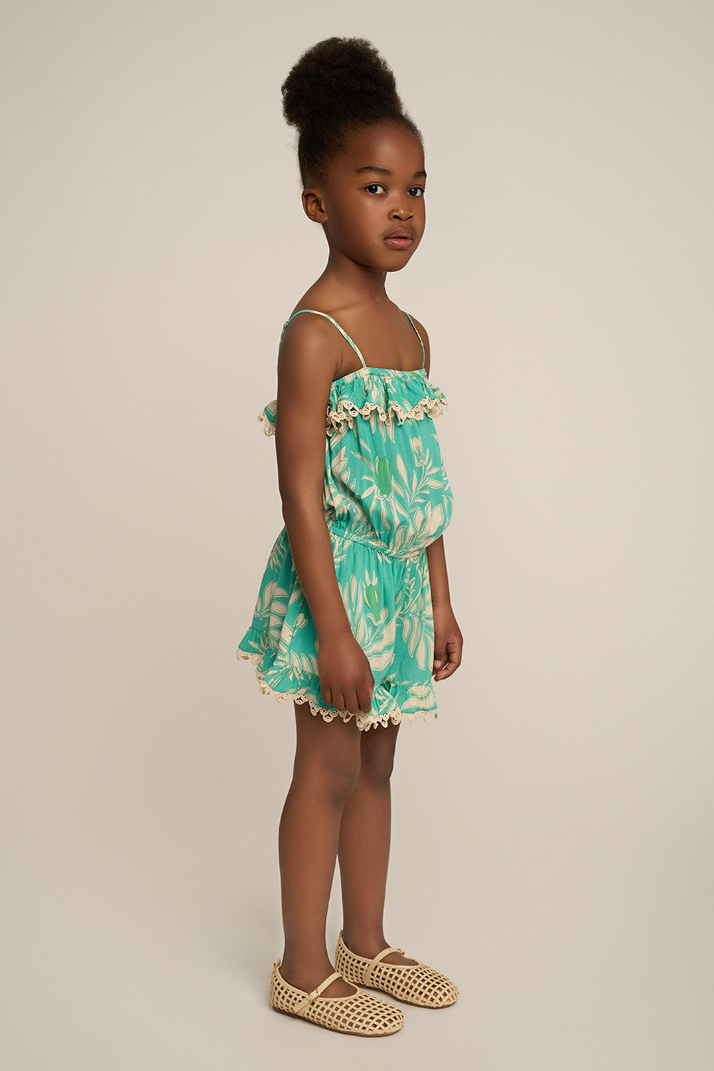 Girl wearing Aqua Kerylos short jumpsuit Angel by Poupette St Barth, showing the side view of the stylish, comfortable jumpsuit.