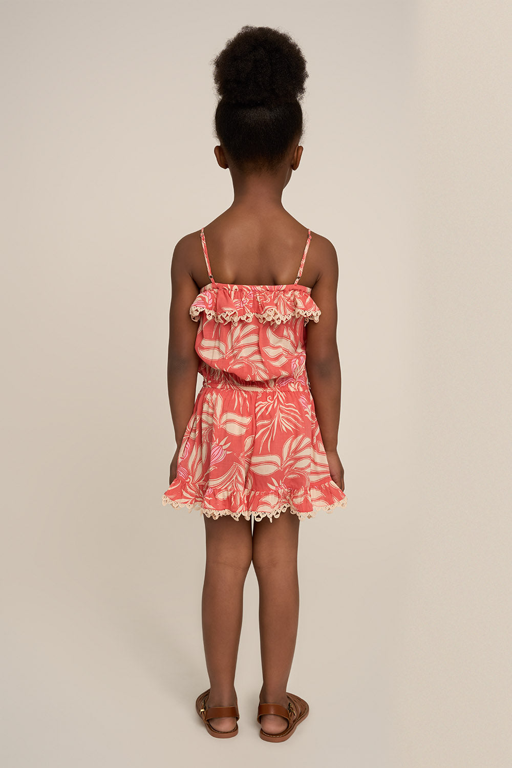 Pink Poupette St Barth girls' short jumpsuit Angel with flutter sleeves, back view showing fitted waist and soft fabric.