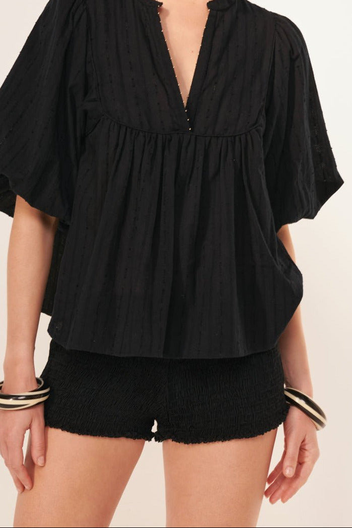 Black blouse – Blouse Flores by Poupette St Barth, front view with split neckline, styled with shorts