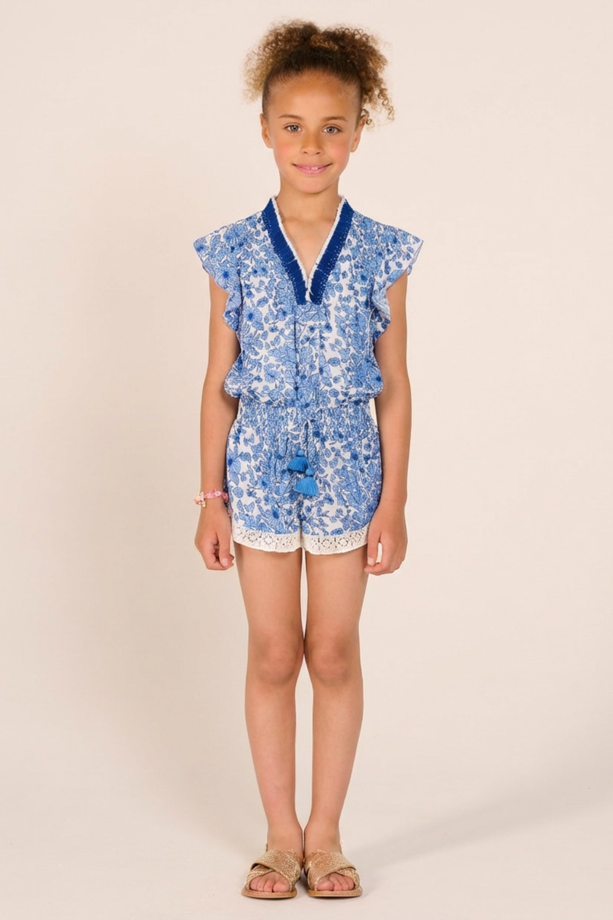 Girls' Blue Aquaflora jumpsuit – Short Jumpsuit Sasha by Poupette St Barth, front view with tassel tie waist