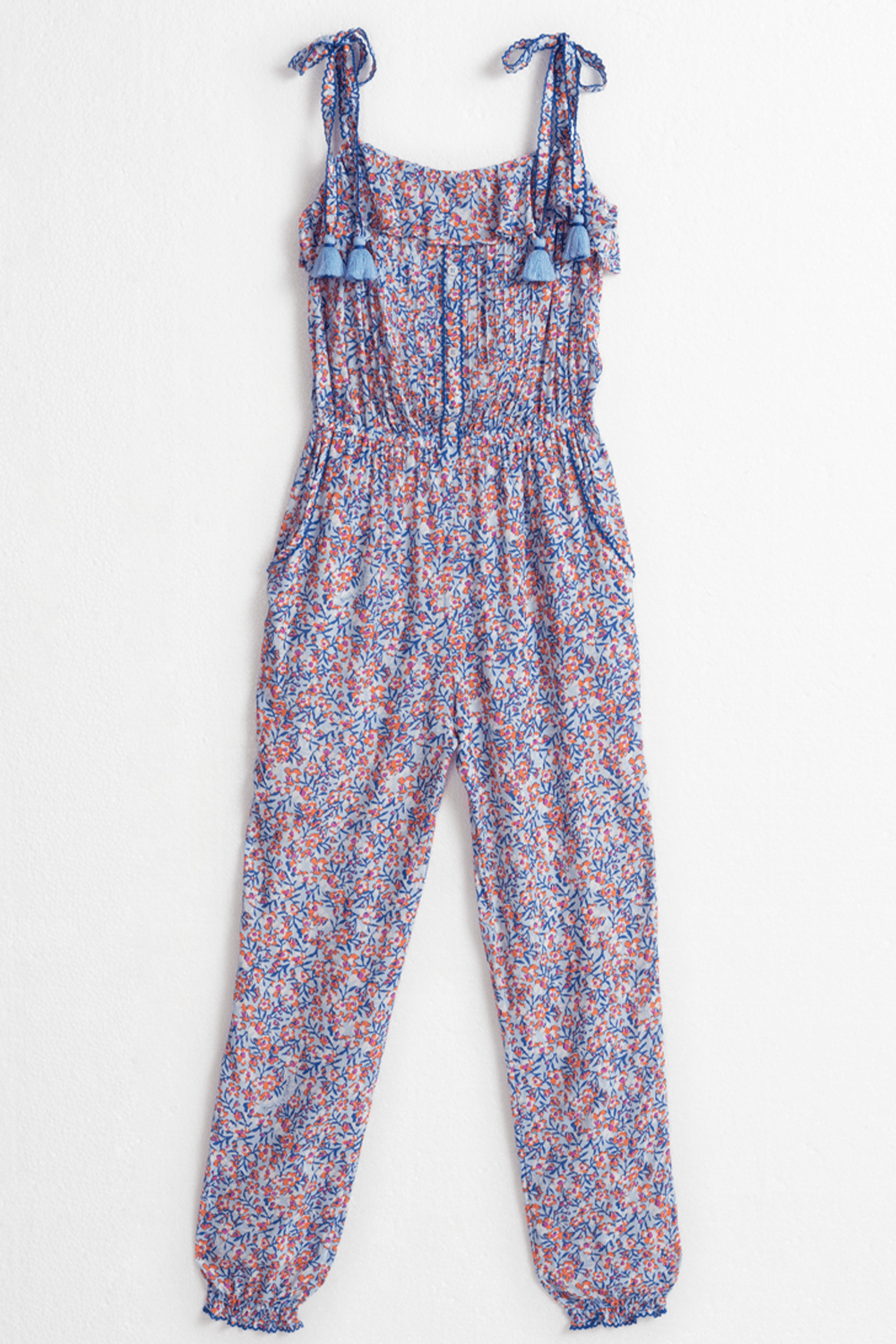 Kids long jumpsuit Astra by Poupette St Barth in light blue with paquerette floral print, front view showing its relaxed fit.