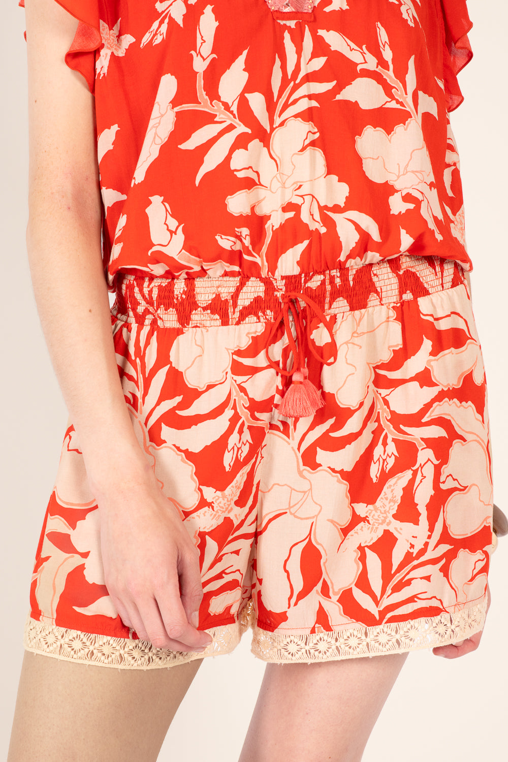Coral short jumpsuit from Poupette St Barth Sasha collection with a relaxed fit and palm beach print.