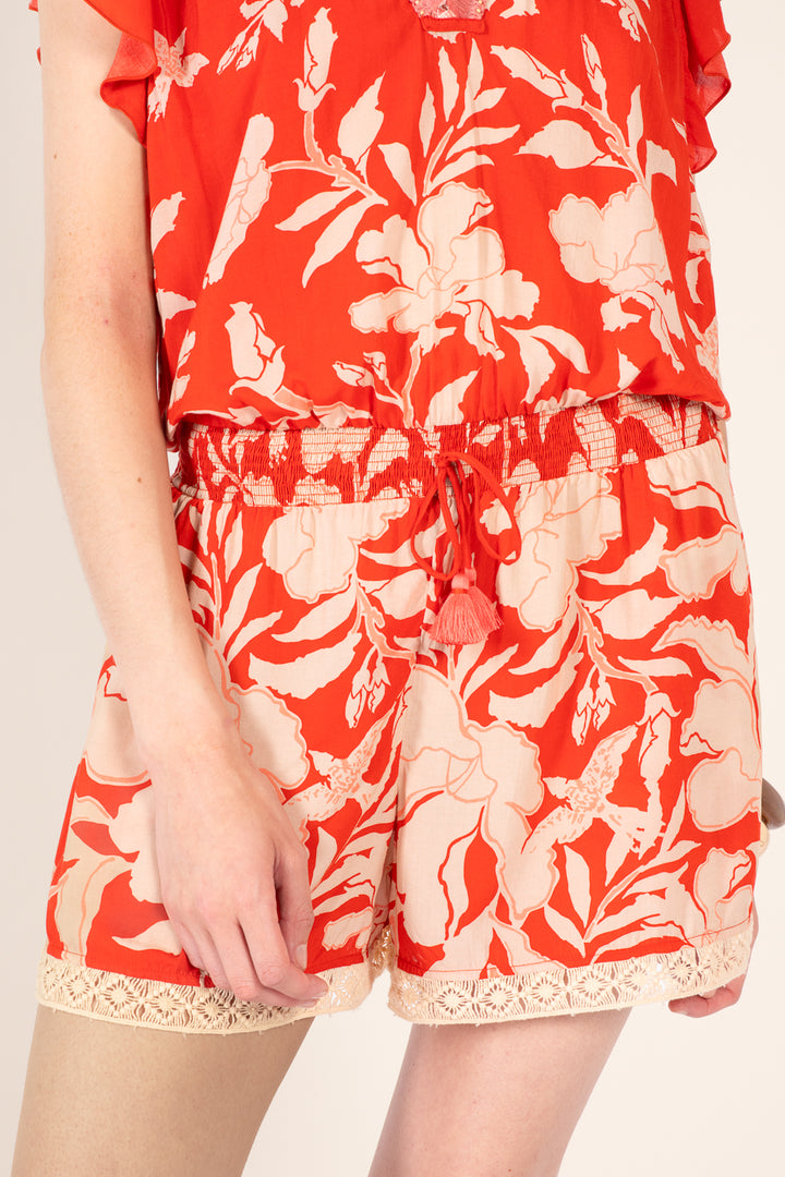 Coral short jumpsuit from Poupette St Barth Sasha collection with a relaxed fit and palm beach print.