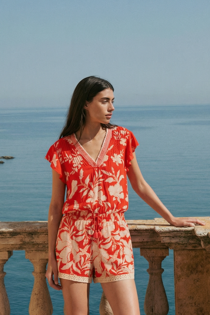 Coral palm print Short Jumpsuit Sasha by Poupette St Barth displayed on a mannequin, featuring a relaxed fit and tropical pattern.