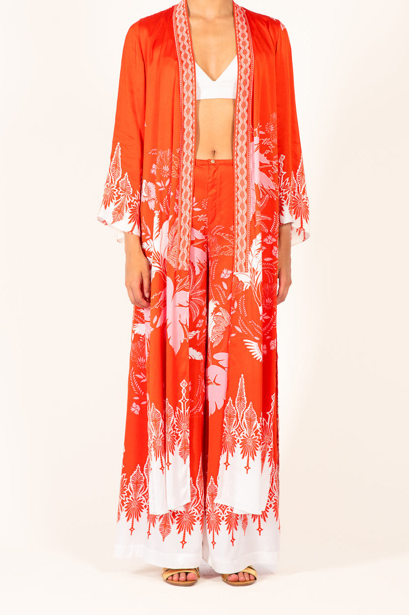 Poupette St Barth Kimono Lea in Coral Canopy, lightweight satin cover-up with flowing sleeves, worn open over beachwear.