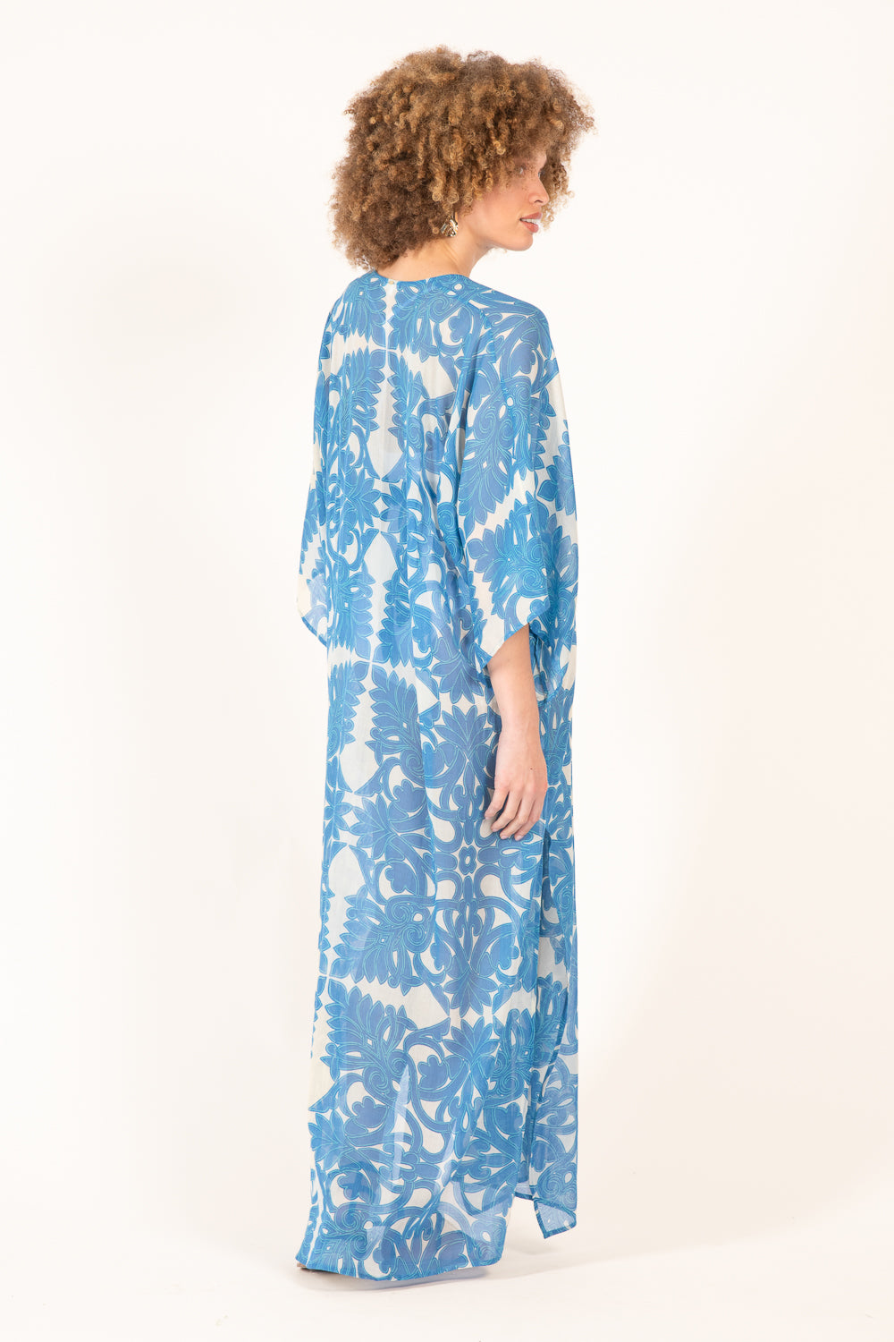 Blue long Kaftan Sol dress by Poupette St Barth featuring flowing fabric and vibrant blue color.