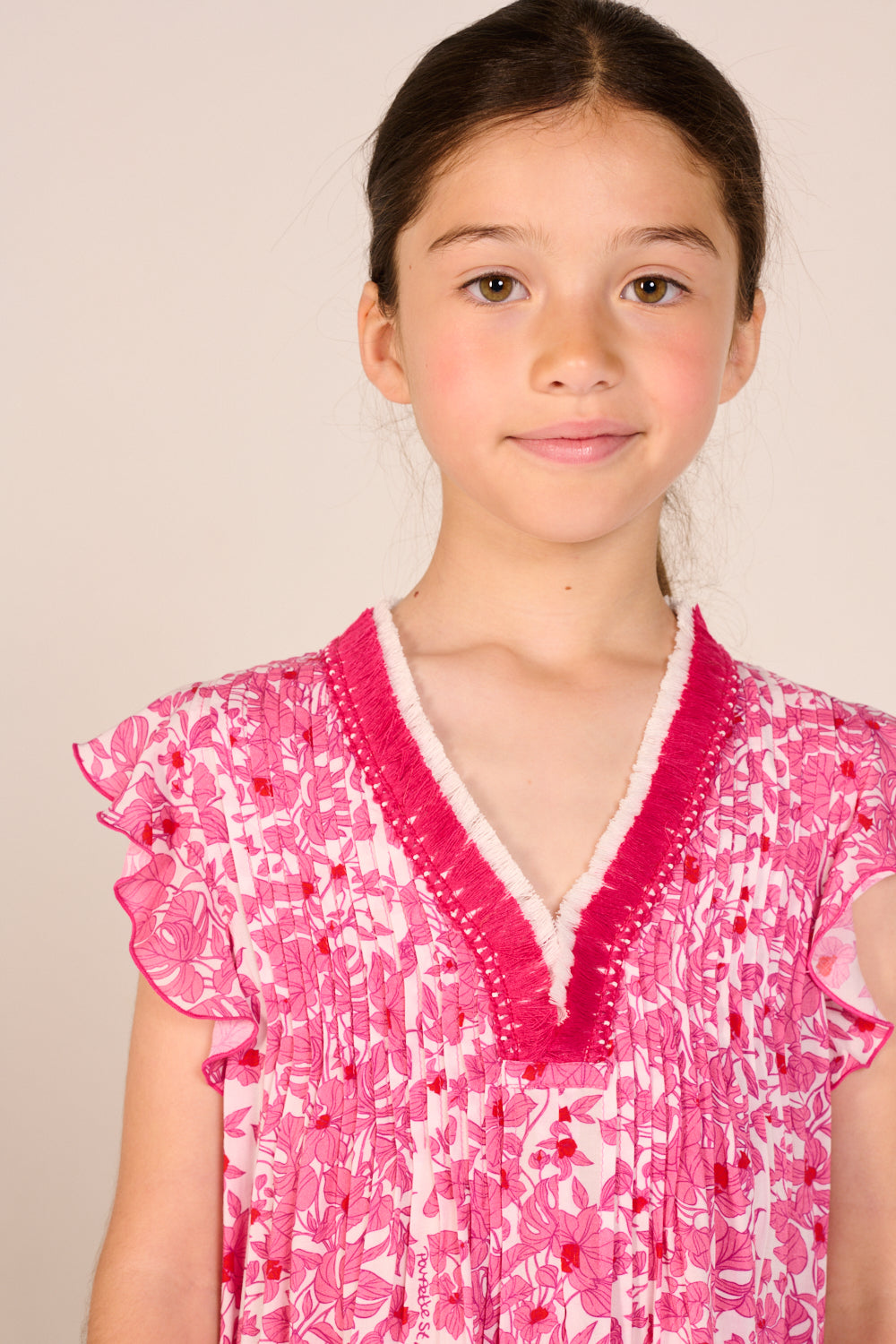 Girls' Pink Aquaflora mini dress – Mini Dress Sasha by Poupette St Barth, close-up of trimmed v-neck and pintucks