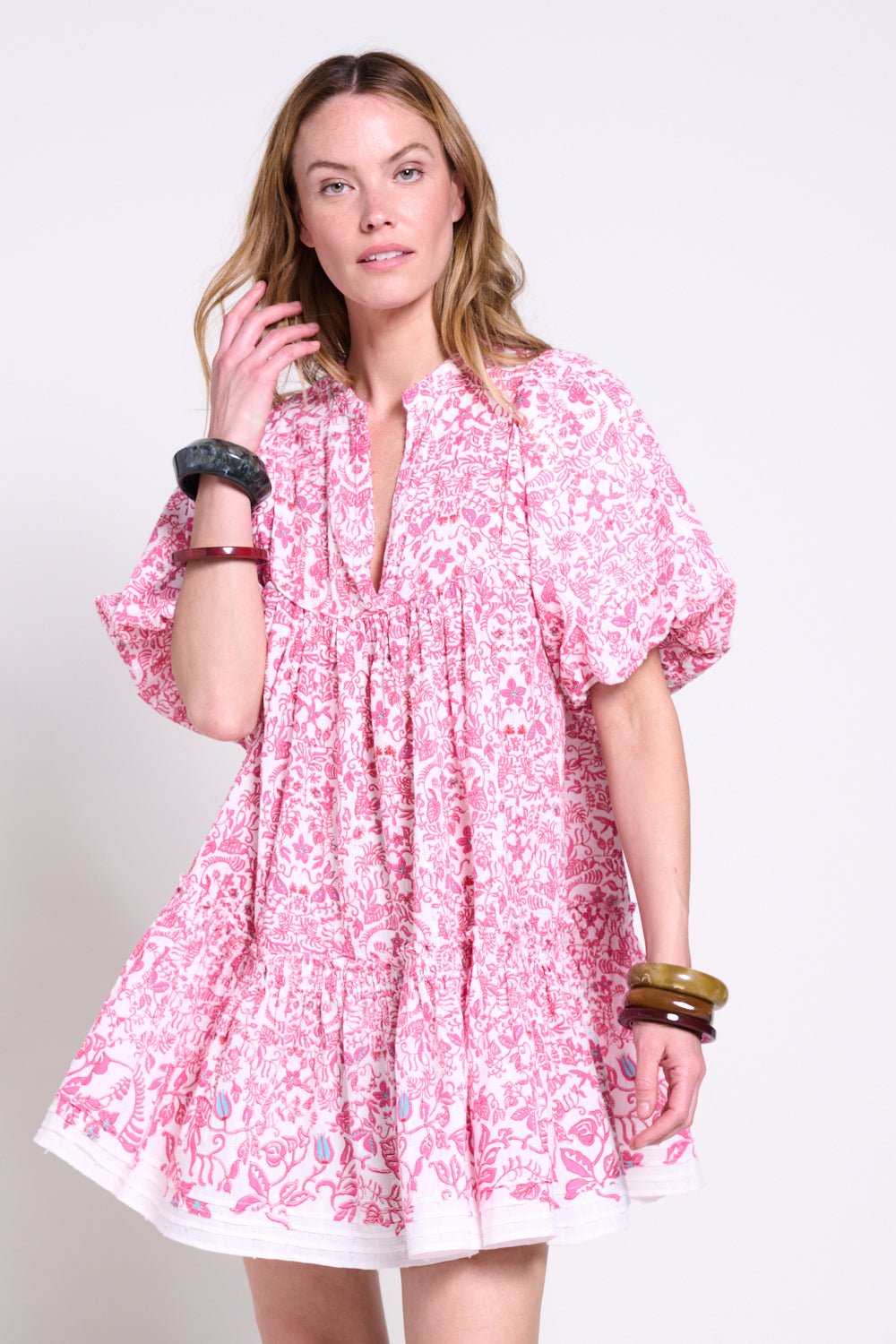 Pink Poupette St Barth Mini Dress Cruz with ruffled sleeves and tropical print, displayed on a mannequin.