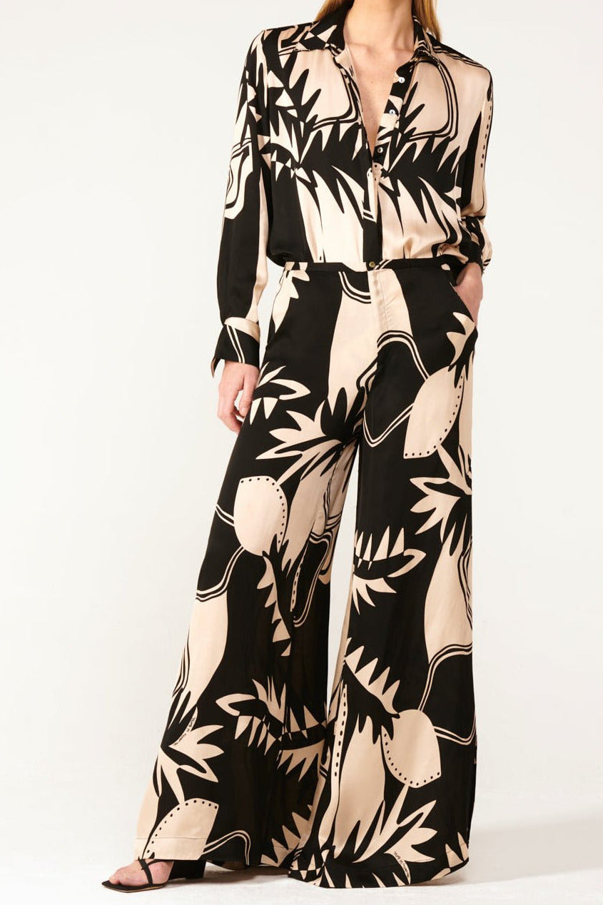 Black viscose satin pants from Poupette St Barth, model Pant Clea in the Black Oasis color, shown on a model.