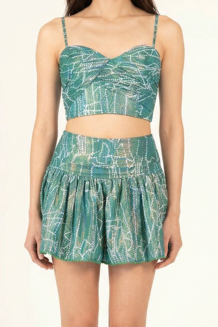 Green metallic cotton mini skirt named Colleen by Poupette St Barth, shown in a close-up image highlighting fabric and fit.