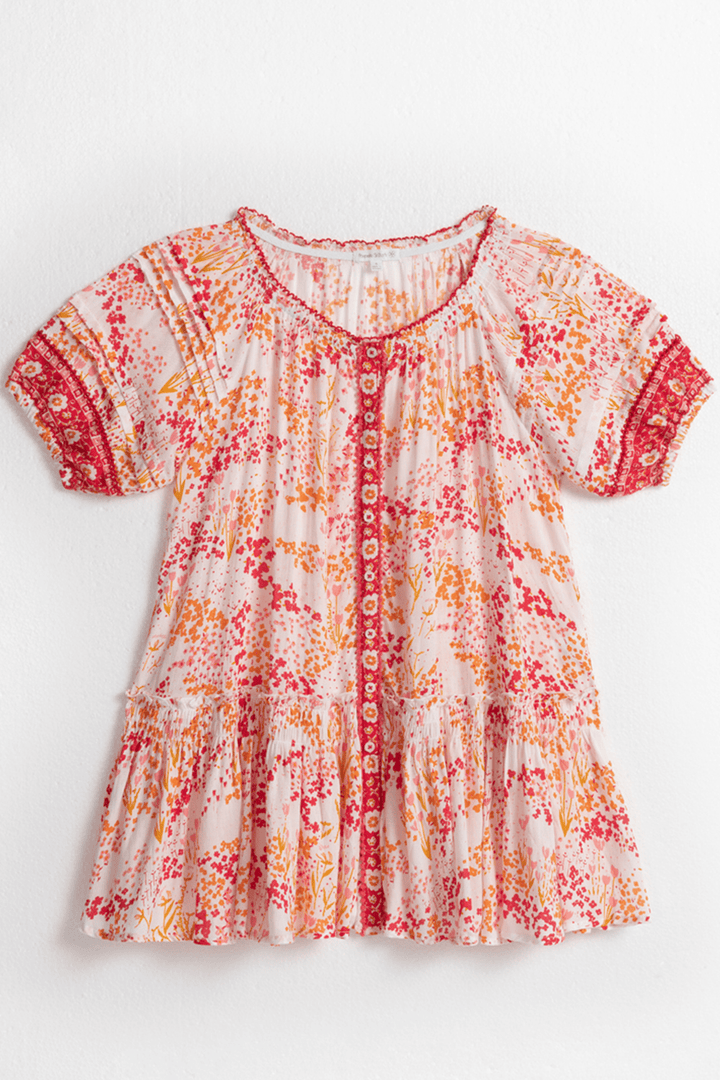Kids mini dress by Poupette St Barth featuring a white and pink tulip pattern, shown from the front.